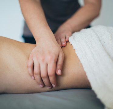 Close-up of a woman receiving a therapeutic massage in a serene spa setting with a white towel.